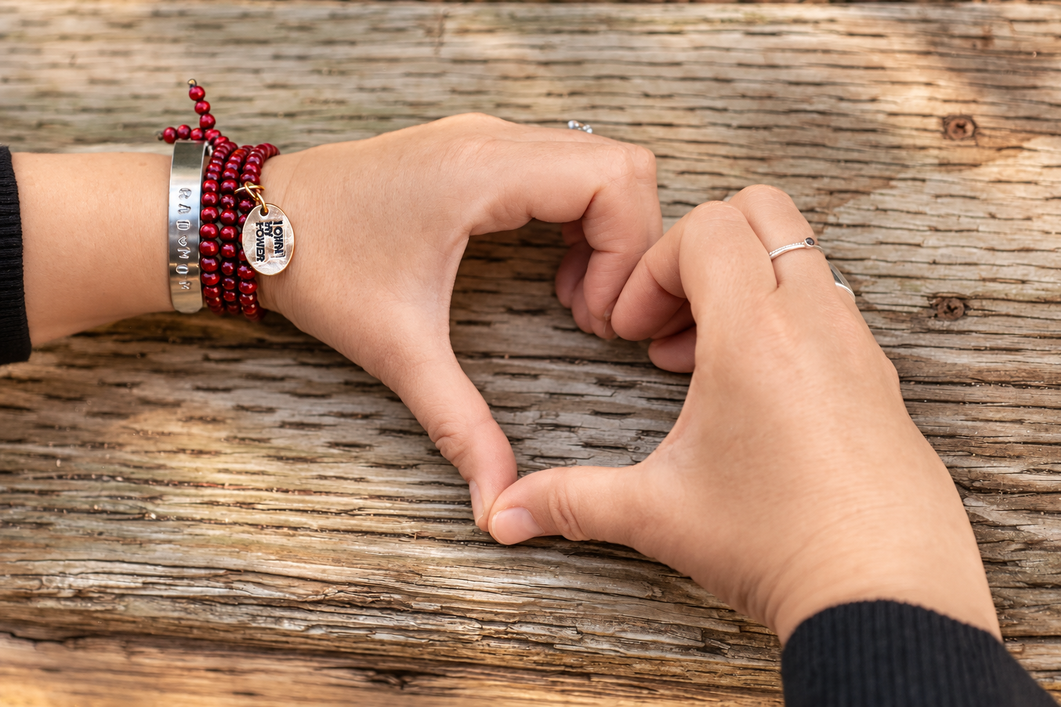Hands forming a heart, with a RAD mom bracelet