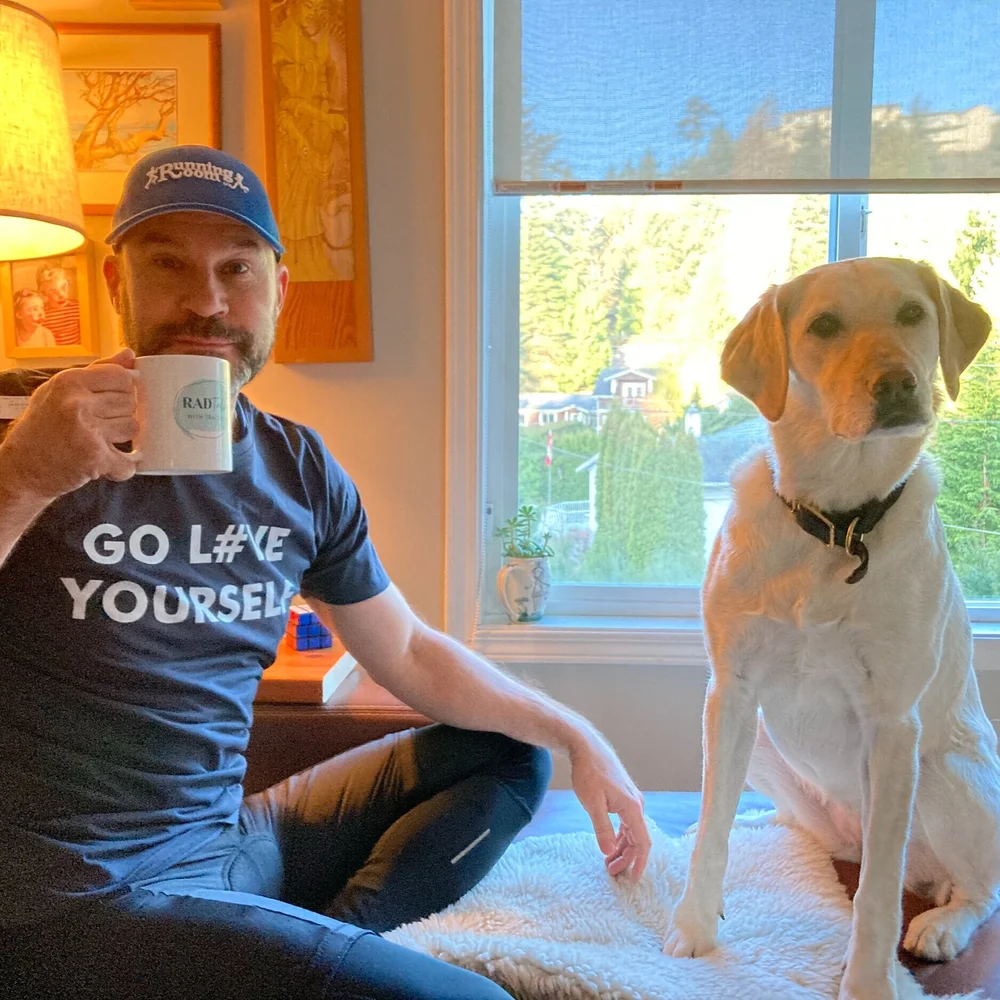 Dwayne seated beside his dog