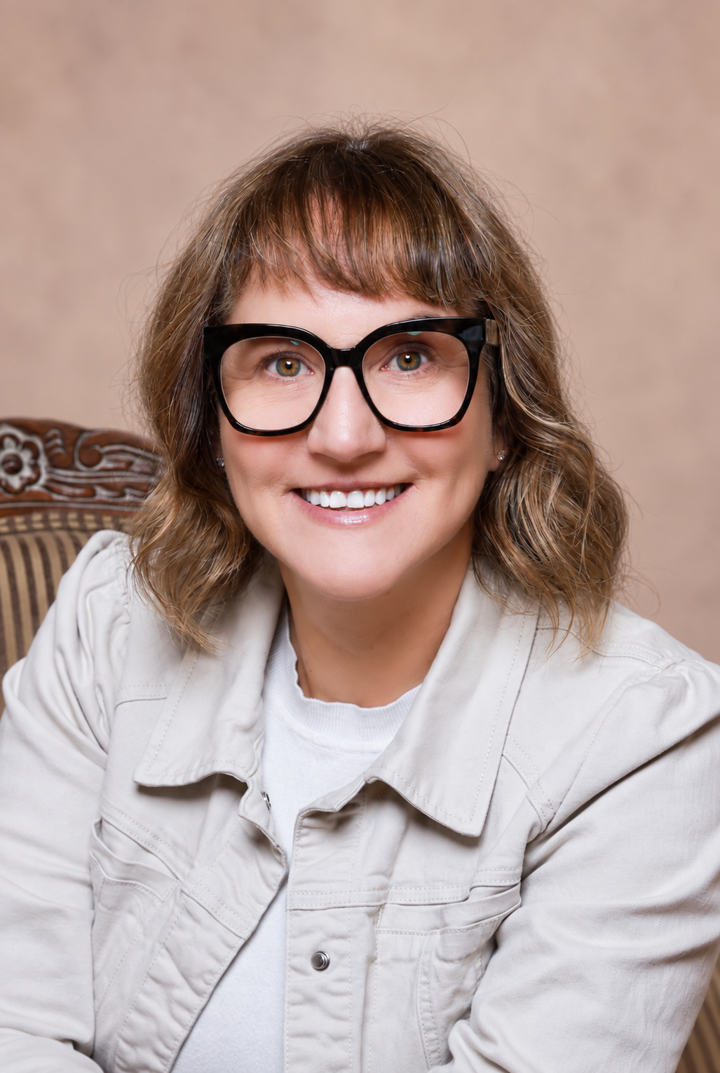 Tracey smiling against a soft blush background