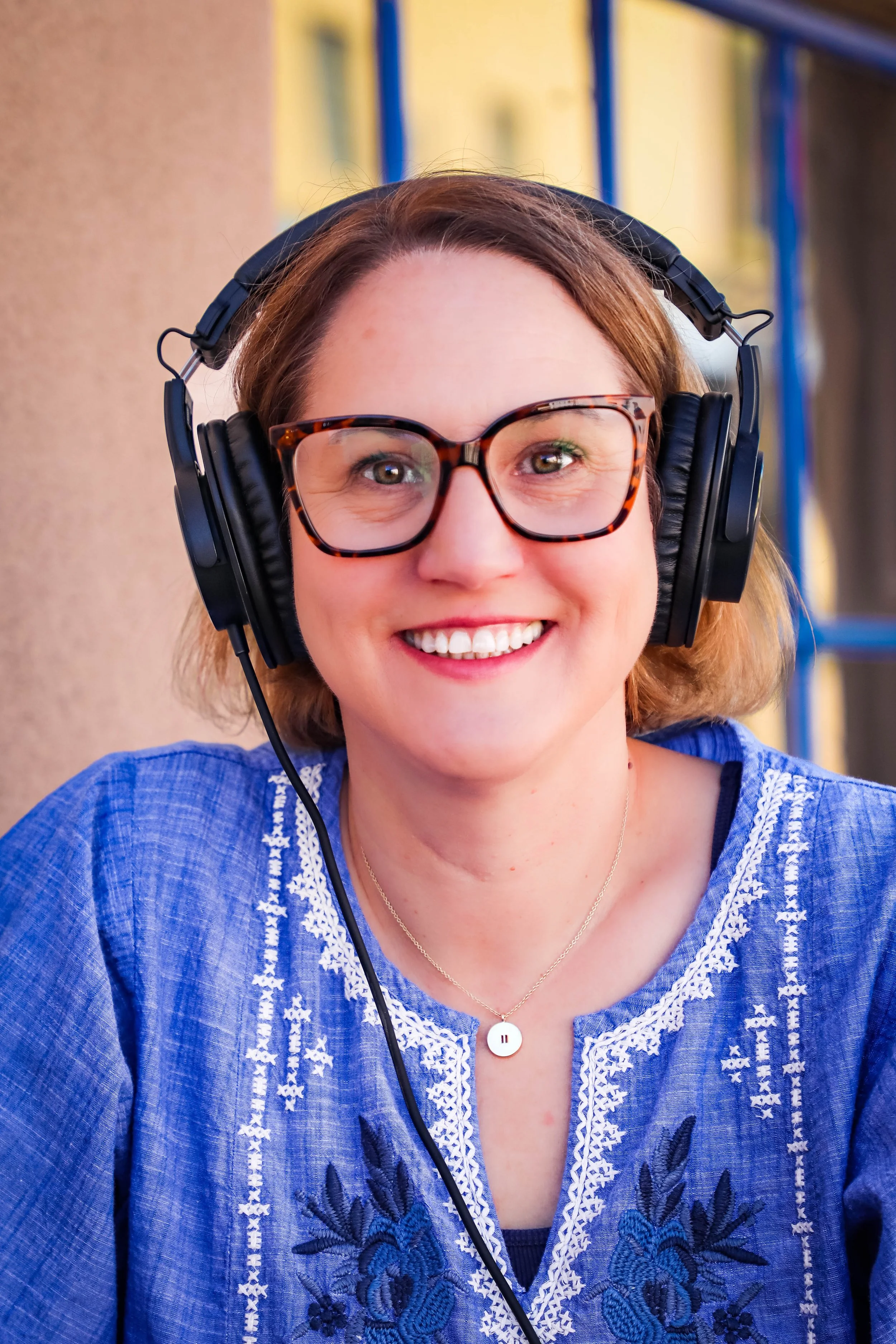 Tracey smiling while wearing podcast headphones